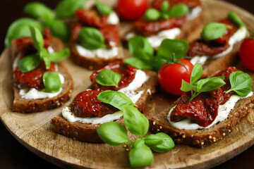Bruschetta with dried tomatoes and basil. Open sandwiches on rye bread with tomatoes.