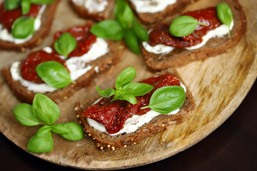 Bruschetta with dried tomatoes and basil. Open sandwiches on rye bread with tomatoes.
