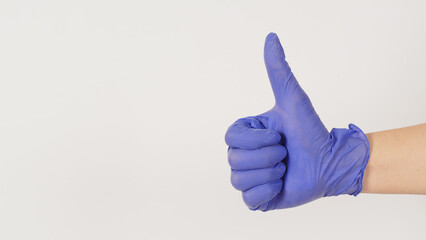 The hand is wearing a violet or purple latex glove and do like handsign on white background.