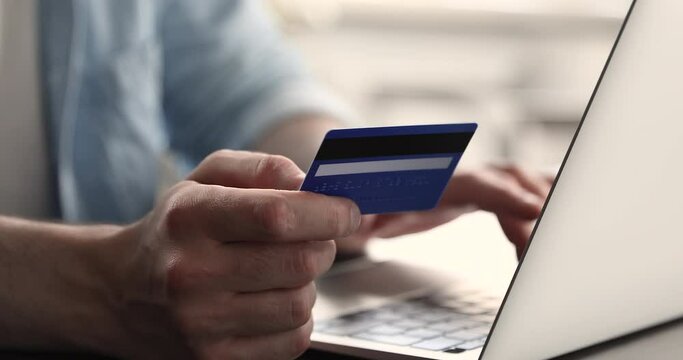 Close up of young male customer hands hold credit card type on laptop use modern day fast easy way of online payment via internet banking. Millennial man client make order buy goods at ecommerce store