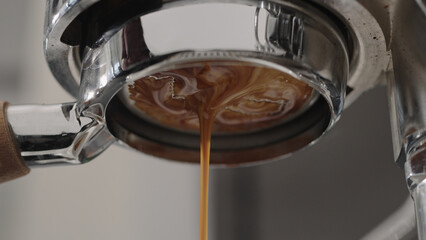 pour espresso with bottomless portafilter closeup