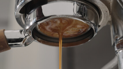 pour espresso with bottomless portafilter closeup