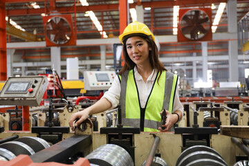 the lady worker or operator has operate the machine in production line factory, young woman check or inspection the safety or quality in plant 