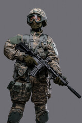 Portrait of professional servicewoman with rifle dressed in camouflage clothes against grey background.
