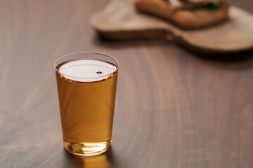 Organic apple cider in tumbler glass on wood table