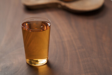 Organic apple cider in tumbler glass on wood table