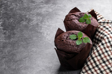 Dark chocolate muffin stuffed with jam on gray background