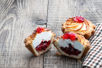 Homemade delicious tarts filled with jam on wooden table