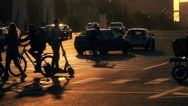 Slow motion shot of unknown food delivery couriers silhouettes and city street traffic