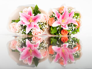 Bouquet made with beautiful arrangement of fresh flowers, roses, lily, green leaves with copy space and reflection on floor