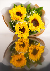 Luxury elegance beautiful bouquet made of fresh bright yellow sunflowers and green leaves.