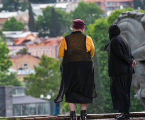 women standing at edge overlooking the city