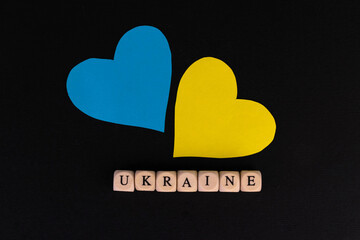 Two hearts in the colors of the flag of Ukraine and the inscription Ukraine on a black background. Patriotic design.