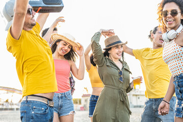 dancing party at the beach, group of young women and men of different ethnicities having fun,...