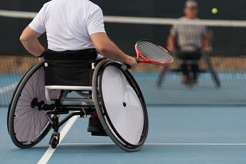 Men on wheelchair playing tennis on tennis court