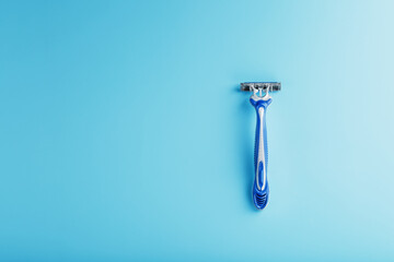 Shaving machine for the face on a blue background top view free space