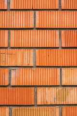 Wall, background, texture of brown, red, orange corrugated bricks.