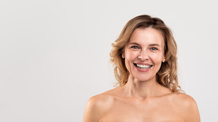 Fototapeta premium Natural Beauty. Portrait Of Attractive Smiling Middle Aged Woman With Naked Shoulders
