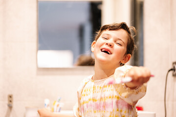 elementary happy girl cleans her teeth