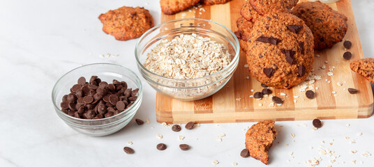 Banner of homemade oat cookies with chocolate. Healthy breakfast served on wood board. Rustic snack for a healthy lifestyle.
