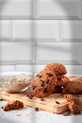 Close up of homemade oat cookies with chocolate. Healthy breakfast served on wood board. Rustic snack for a healthy lifestyle.