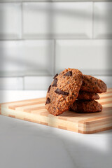 Close up of homemade oat cookies with chocolate. Healthy breakfast served on wood board. Rustic snack for a healthy lifestyle.