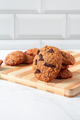 Close up of homemade oat cookies with chocolate. Healthy breakfast served on wood board. Rustic snack for a healthy lifestyle.