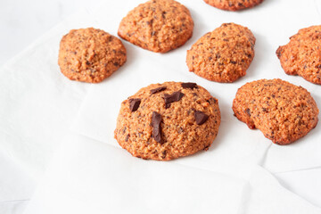 Homemade oat cookies with chocolate over white background. Rustic snack for a healthy lifestyle.