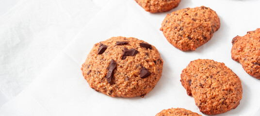 Homemade oat cookies with chocolate over white background. Rustic snack for a healthy lifestyle.