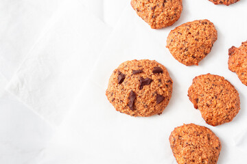 Homemade oat cookies with chocolate over white background. Rustic snack for a healthy lifestyle.