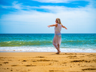 Woman walking on sunny beach
