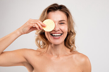 Skincare Fun. Middle Aged Woman Covering Eye With Cosmetic Sponge And Laughing