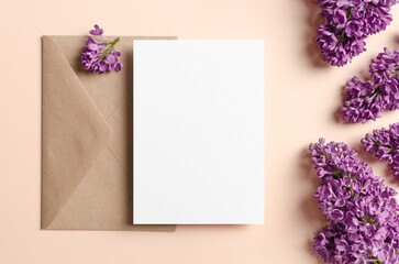 Blank wedding invitation card mockup with envelope and spring lilac flowers