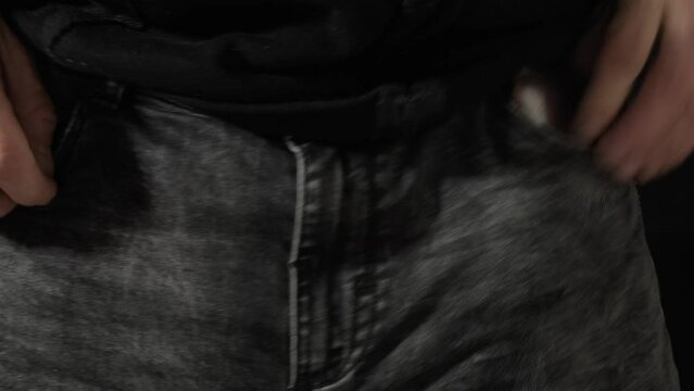 A man caressing his crotch (the part of the body where the legs join at the top) with his hands and offering money from his wallet, making a vulgar unsolicited sexual offer.
