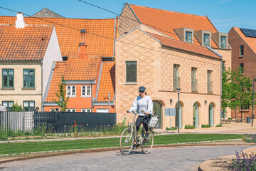 Beautiful girl riding a bike on a new bike path or road between modern buildings in the center of...
