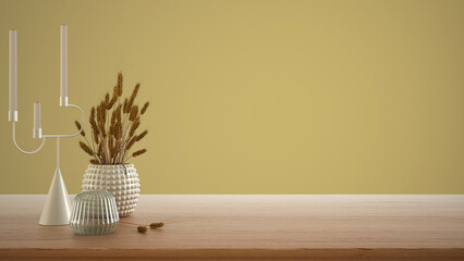 Empty interior design concept, wooden table, desk or shelf close up. Ceramic and glass vases with dry plants, straws. Yellow background with copy space, template mock up idea