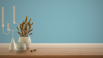 Empty interior design concept, wooden table, desk or shelf close up. Ceramic and glass vases with dry plants, straws. Blue background with copy space, template mock up idea