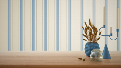 Empty interior design concept, wooden table, desk or shelf close up in blue tones. Ceramic and glass vases with dry plants, straws. Striped wallpaper with copy space, template