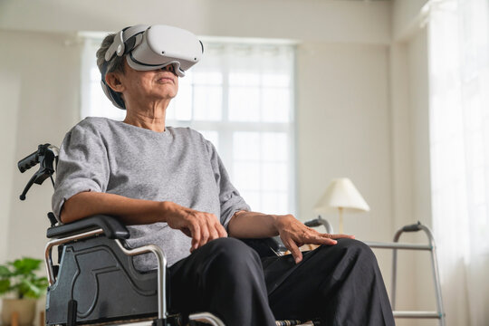 lonely ole male Disabled Senior Man in a Wheelchair Gesturing and concentrate While Wearing the Virtual Reality Goggles at Home in the Livingroom,Shot of a senior man in a wheelchair wear vr headset