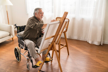 old senior asian male using art therapy while his legs is injured at home,asian elder man spend...
