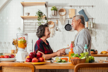 Asian senior adult couple cooking healthy food together at home while dancing in the kitchen morning weekend,happiness asian old marry couple enjoy romantic Cropped shot of a senior couple dancing