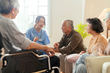 happiness Cheerful elderly woman and men talking with female caregiver nurse doctor having health checking consult at living area,Caretakers with senior couple sitting in living room at nursing home