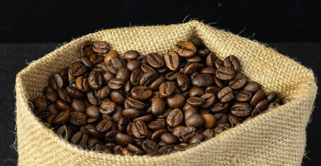 freshly picked coffee beans inside the sack, black background