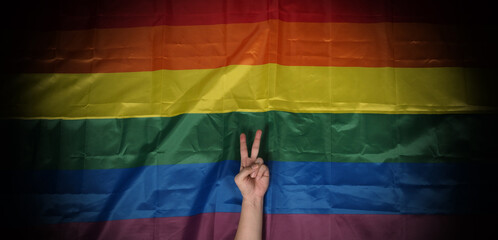 LGBTQ pride flag on black background. Lgbt rainbow flag in gay hand. Represent symbol of freedom...