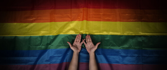 LGBTQ pride flag on black background. Lgbt rainbow flag in gay hand. Represent symbol of freedom...