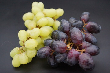 Trauben in Rot u.Weiss sowie Bananen mit schwarzen und blauen Hintergrund