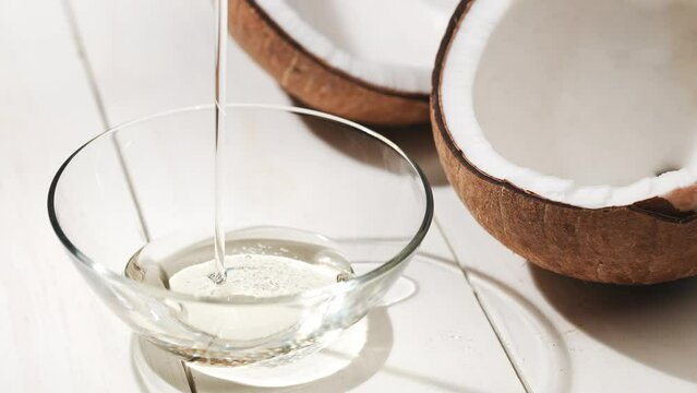 割られたココナッツから見える胚乳とココナッツオイル