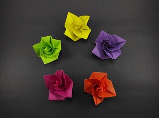 Five colored origami rose flower isolated on black background, Not Focus