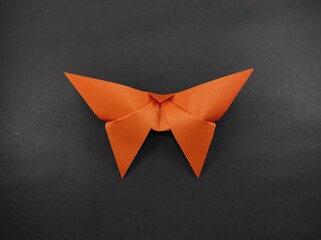 Paper butterfly in orange color isolated on black background, Not Focus