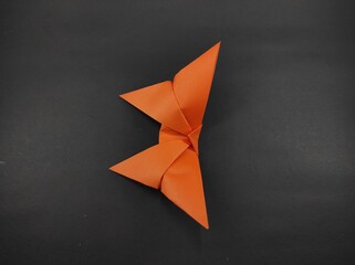 Paper butterfly in orange color isolated on black background, Not Focus